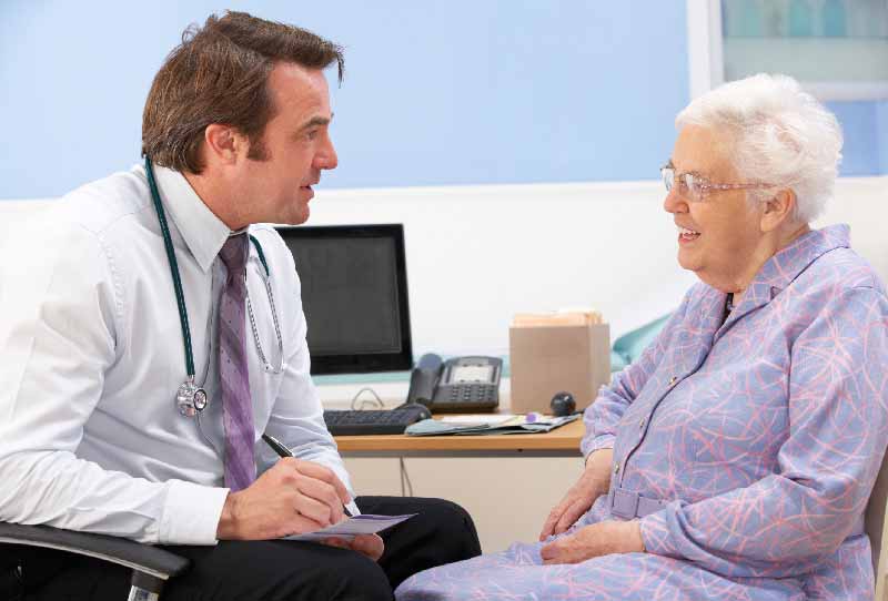 Läkare samtalar med en äldre patient